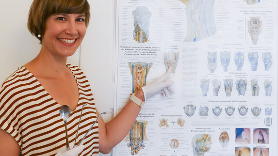 Dozentin zeigt anatomisches Poster während einer Fortbildung im Bereich Logopädie.